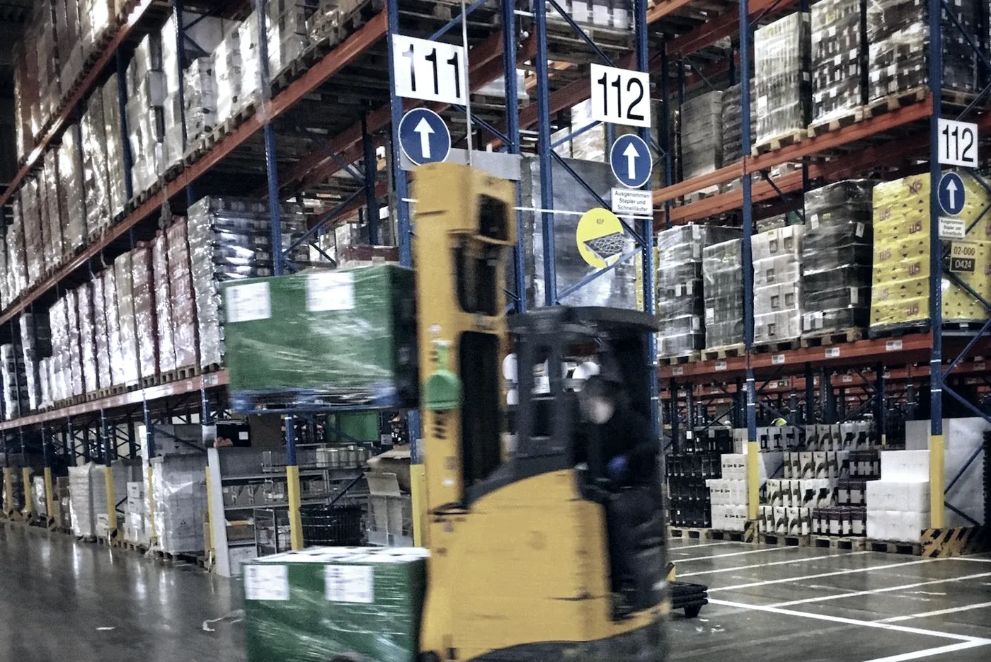Reach truck between high racks in a warehouse